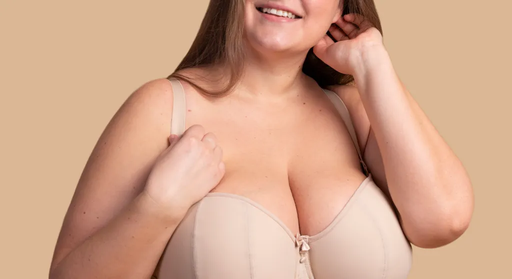 Mujer feliz con los resultados de una mamoplastia reductora, mostrando el alivio del dolor y la mejora postural tras la cirugía en Madrid.