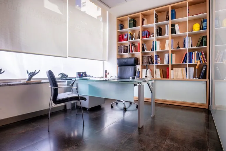 Consultorio moderno y elegante de cirugía plástica y medicina estética del Dr. César Casado en Madrid, con mobiliario confortable y luz natural, ideal para primeras consultas y seguimiento.