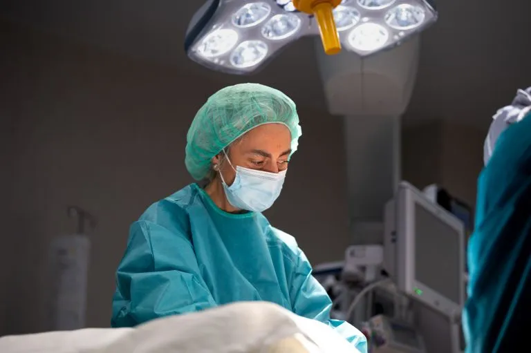 Dra. María del Mar Vaquero Pérez, cirujana plástica con bata médica, sonriendo profesionalmente en su clínica.